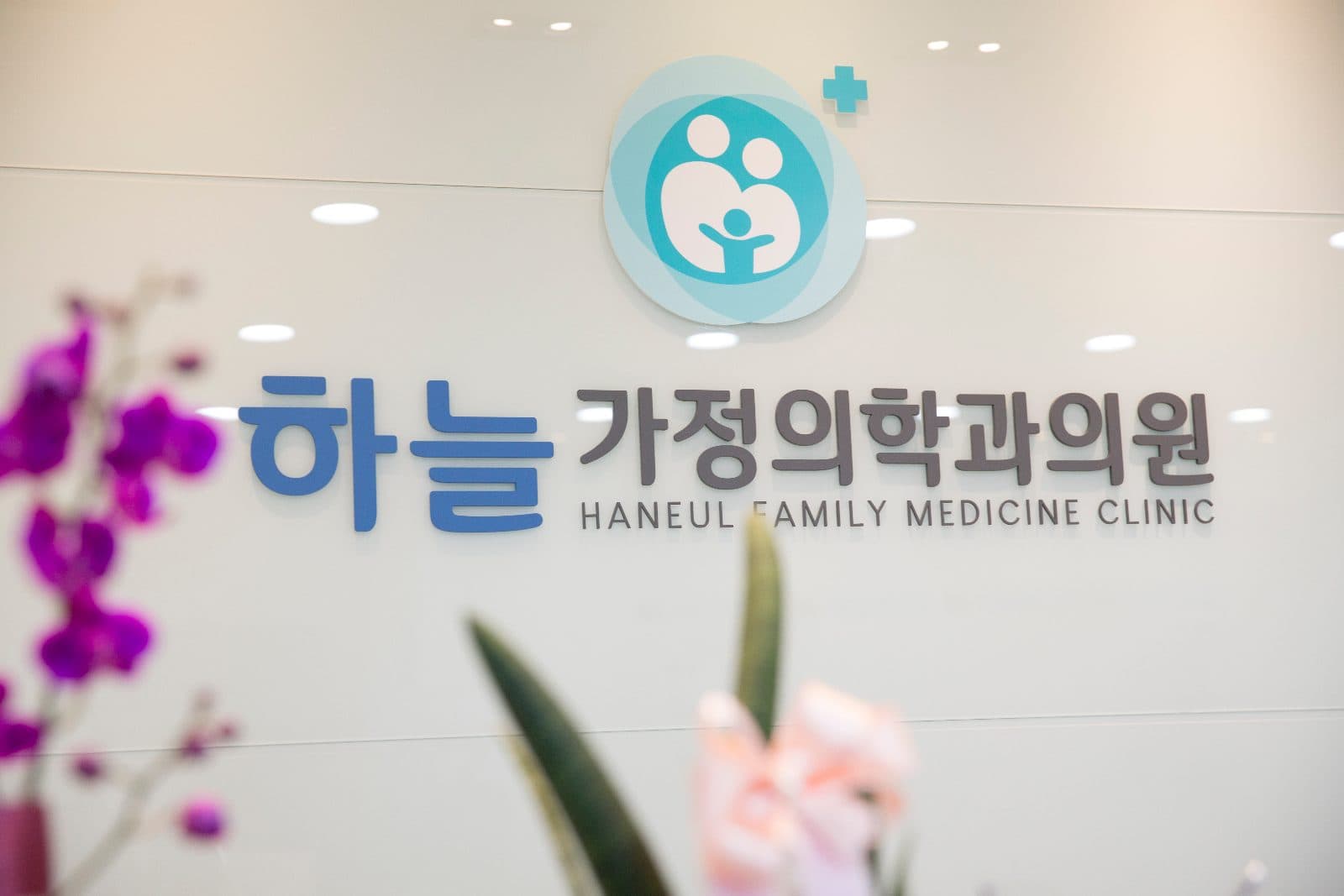 하늘가정의학과의원 접수 데스크 뒤 로고 사인월